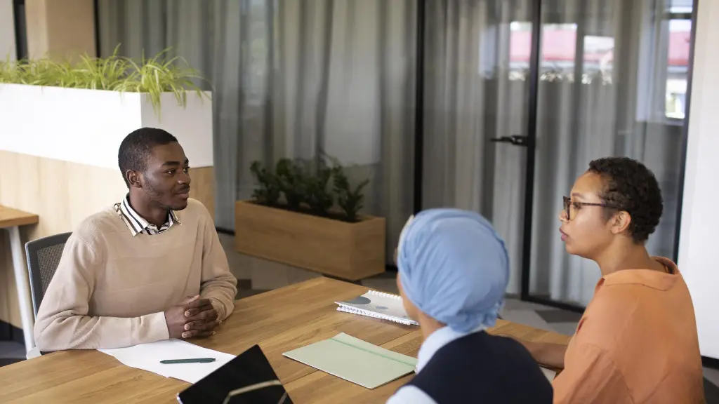 man-sitting-down-office-job-interview-desk-with-his-employers (1).webp