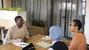man-sitting-down-office-job-interview-desk-with-his-employers (1).webp